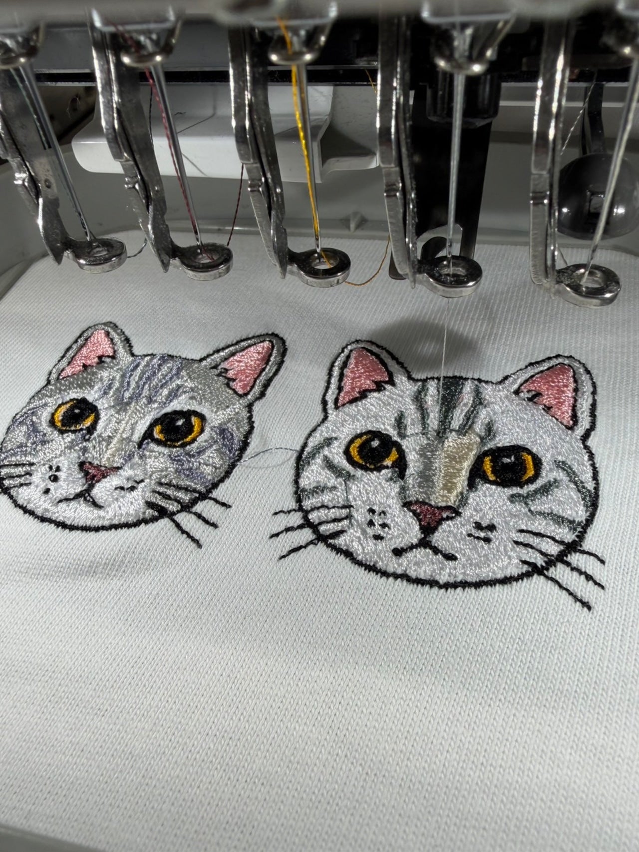 お客様のペットの猫の顔デザインを刺繍している様子